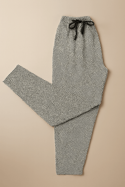 Men's geometric print drawstring trousers on beige background – clean product flat lay