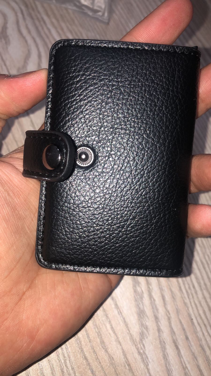RFID leather wallet held in hand showing premium black texture