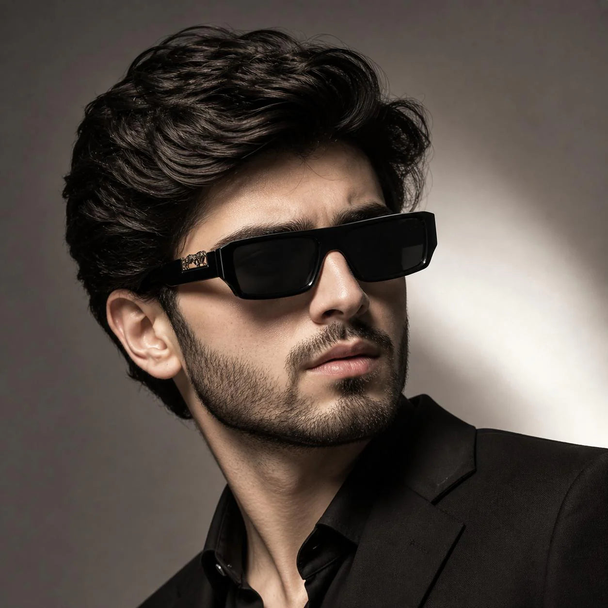 Man wearing black rectangular sunglasses with gold leopard logo detail – side profile lifestyle shot