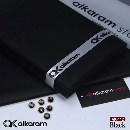 Alkaram Studio AK-112 Black unstitched cotton fabric folded with branded ribbon buttons and Alkaram Studio brand tag on white background