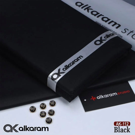 Alkaram Studio AK-112 Black unstitched cotton fabric folded with branded ribbon buttons and Alkaram Studio brand tag on white background