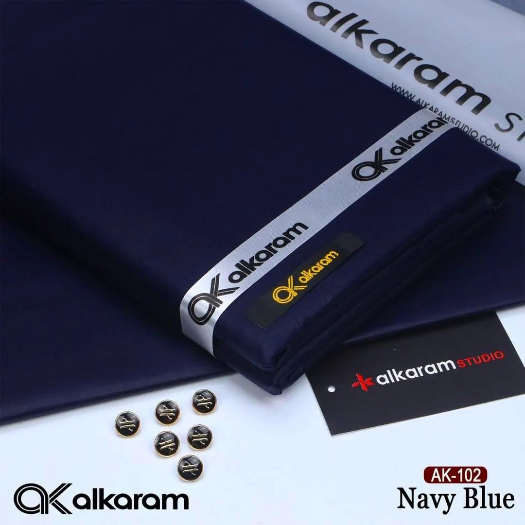 Alkaram Studio AK-102 Navy Blue unstitched cotton fabric close up showing fabric texture with branded ribbon and buttons