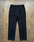 Black dri-fit plain drawstring trouser laid flat on wooden floor – full length top view product shot
