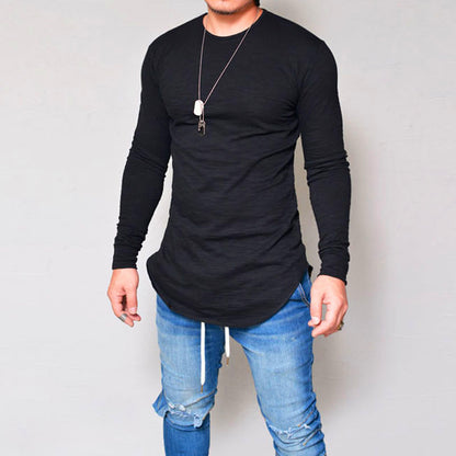 Man wearing black slim fit long sleeve round neck curved hem t-shirt with ripped jeans – front lifestyle model shot on grey background