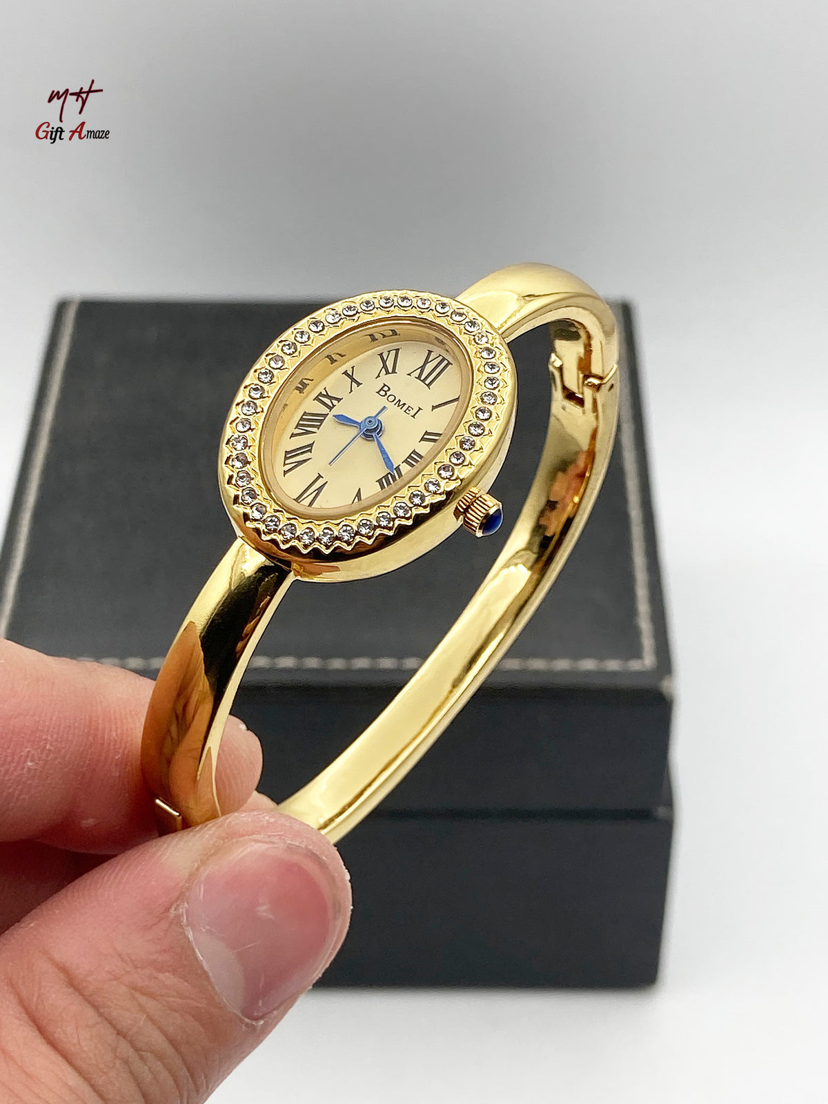 BOMEI gold bangle watch on mirror surface reflection