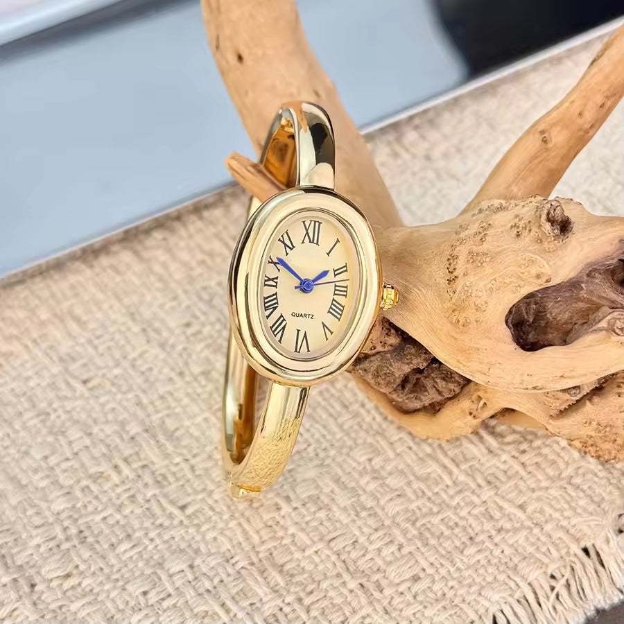 BOMEI gold bangle watch on wrist with champagne dial