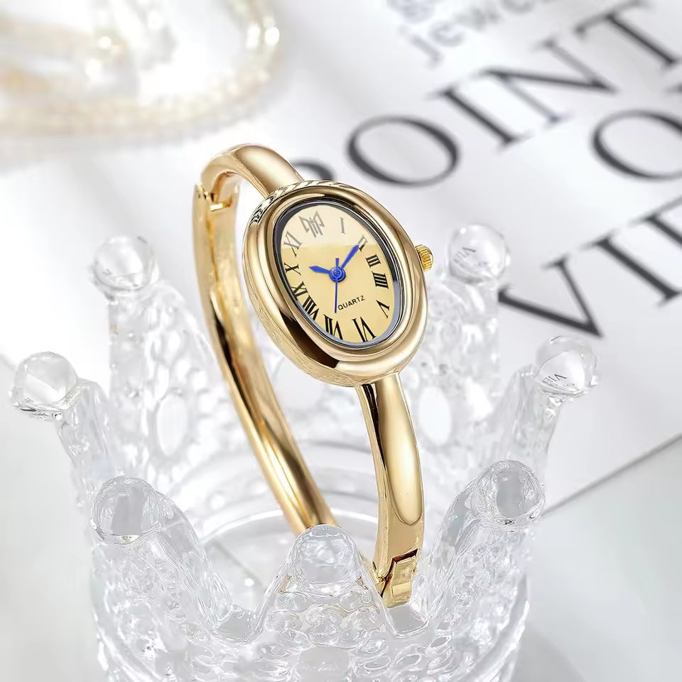 BOMEI gold bangle watch on crystal display side view