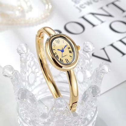 BOMEI gold bangle watch on crystal display side view