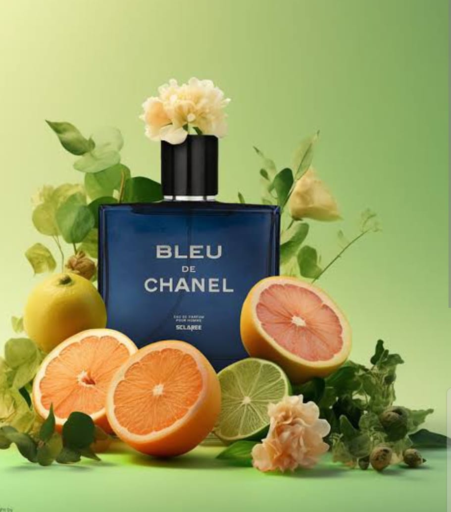 Bleu De Chanel navy blue bottle surrounded by citrus fruits and flowers