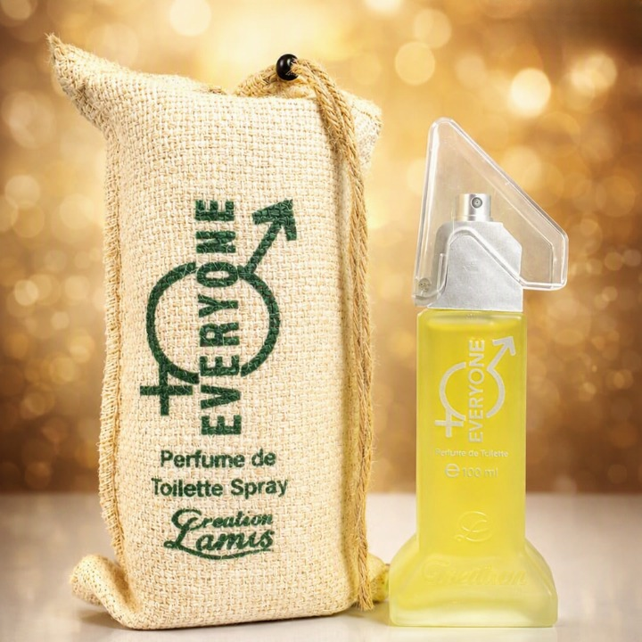 Creation Lamis Everyone perfume bottle and pouch on golden bokeh background